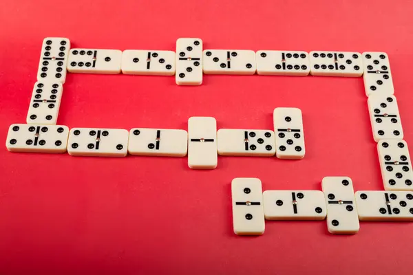 stock image Dominoes with red background, copy space and various angles, board games concept.