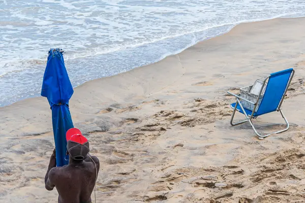 Salvador, Bahia, Brezilya - 15 Haziran 2019: Bahia 'nın başkenti Salvador' da bir sokak satıcısı, turistler için şemsiye yerleştirirken görüldü..