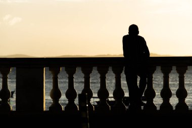 Salvador, Bahia, Brezilya - 15 Haziran 2019: Kimliği belirsiz bir kişi, Bahia 'nın Salvador kentindeki Porto da Barra' da günbatımının keyfini çıkarırken görüldü..