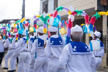 Saubara, Bahia, Brezilya - 3 Ağustos 2024: Geleneksel kıyafetler giymiş Marujada kültür grubu, Chegancas toplantısı sırasında geçit töreni yaparken görülüyor. Saubara, Bahia.