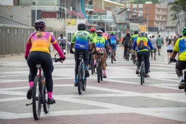 Salvador, Bahia, Brazil - September 01, 2024: A group of cyclists is seen riding in the morning at Farol da Barra. City of Salvador, Bahia. clipart