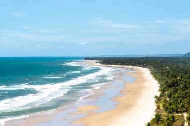 Açık gökyüzüne karşı mavi suları olan güzel bir sahil manzarası. Itacare, Bahia.
