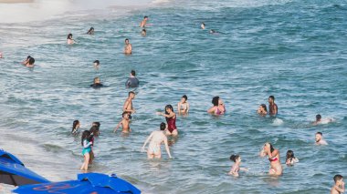 Salvador, Bahia, Brezilya - 09 Kasım 2019: Turistler sahilde eğlenirken ve banyo yaparken görülüyor. Bahia, Salvador şehri..