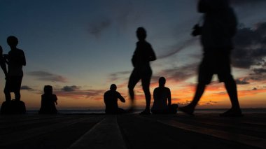 Salvador, Bahia, Brezilya - 09 Kasım 2019: Silüet içindeki insanlar, Bahia 'nın Salvador kentindeki Porto da Barra rıhtımında dramatik günbatımının tadını çıkarıyorlar..