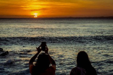 Salvador, Bahia, Brezilya - 14 Kasım 2019: Salvador, Bahia 'da dramatik bir günbatımı sırasında kimliği belirsiz iki kişi siluette görüldü.