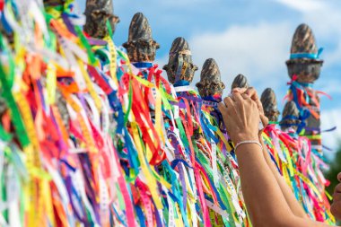 Salvador, Bahia, Brezilya - 27 Aralık 2019: Turistler Salvador, Bahia 'daki Sinyor do Bonfim Kilisesi' nin kapısında renkli hatıra kurdeleleri bağlarken görüldü..