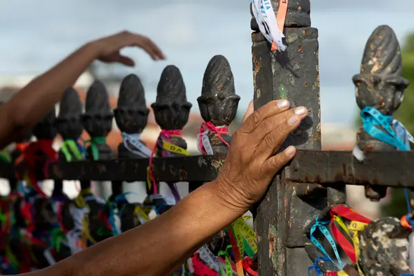 Salvador, Bahia, Brezilya - 27 Aralık 2019: Turistler Salvador, Bahia 'daki Sinyor do Bonfim Kilisesi' nin kapısında renkli hatıra kurdeleleri bağlarken görüldü..