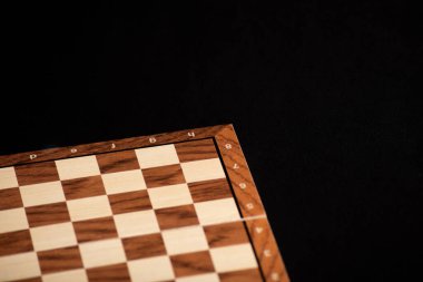 Siyah arkaplanda satranç ya da dama oyununun boş tahta tahtası.