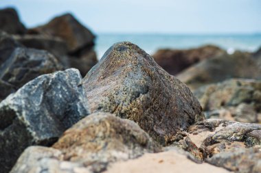 Okyanusa karşı karanlık deniz taşları ve bulutlu gökyüzü manzarası. Doğayı korumuş. Salvador, Brezilya