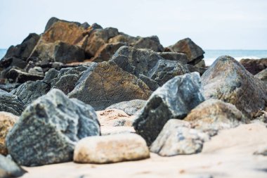 Okyanusa karşı karanlık deniz taşları ve bulutlu gökyüzü manzarası. Doğayı korumuş. Salvador, Brezilya