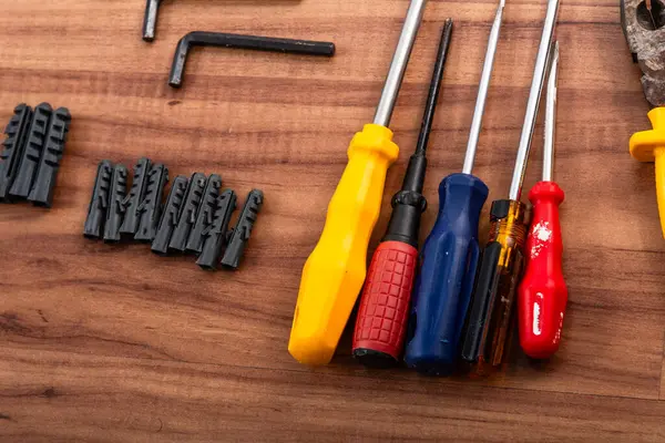 Pense, tornavida, ingiliz anahtarı ve ahşap arka planda izole edilmiş diğer aletler.