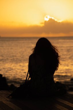 Salvador, Bahia, Brezilya - 21 Aralık 2019: Bahia, Salvador 'da bir yaz gününde günbatımının tadını çıkaran kimliği belirsiz bir adamın silueti.