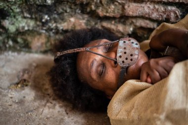 Zincire vurulmuş ve ağzında demir bir maskeyle yerde yatan siyah bir kadının portresi. Brezilya 'da kölelik. Köle Anastacia 'yı temsil ediyorum..