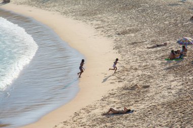 Salvador, Bahia, Brezilya - 6 Temmuz 2019: İnsanlar Salvador, Bahia 'da güneşli bir günde Paciencia plajında güneşlenip güneşleniyorlar..