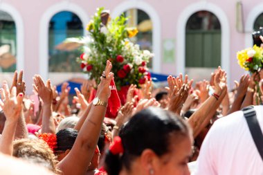 Salvador, Bahia, Brazil - December 04, 2019: Faithful are seen participating in the open-air mass in honor of Saint Barbara in Pelourinho. Salvador, Bahia. clipart