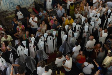 Salvador, Bahia, Brazil - October 20, 2024: Members of the Black Brotherhood are seen praying during mass at the Rosario dos Pretos church. Pelourinho, Salvador, Bahia. clipart