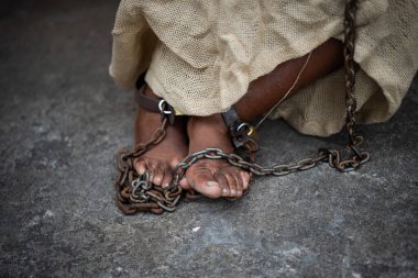 Pelourinho 'nun zemininde oturan siyah bir kadının zincire vurulmuş ayakları. Brezilya 'da kölelik. Köle Anastacia 'yı temsil ediyorum..