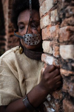 Siyah kadın zincirlenmiş ve ağzında demir bir maskeyle Pelourinho 'nun tuğla duvarlarında köle Anastacia' yı temsil ediyor. Brezilya 'da kölelik. Acı ve acı..