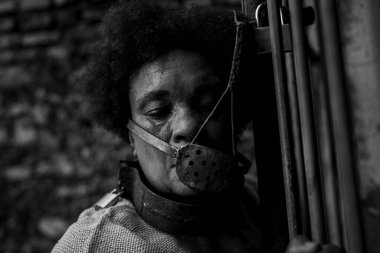 Ağzına demir bir maske takmış siyah bir kadının portresi. Zincirli. Brezilya 'da kölelik. Korku ve üzüntü hissi..