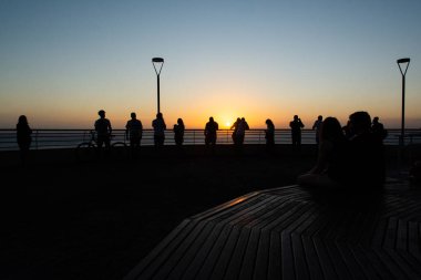 Salvador, Bahia, Brezilya - 19 Eylül 2019: İnsanlar, siluet içinde, Salvador, Bahia şehrinde güzel günbatımının keyfini çıkarırken görülüyor..