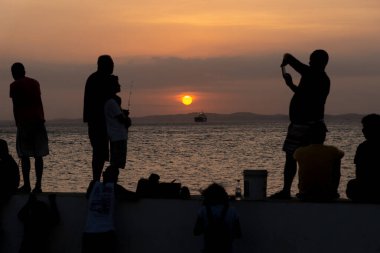 Salvador, Bahia, Brezilya - 16 Kasım 2019: Silhouette 'de birkaç kişinin gün batımında Salvador, Bahia' da dinlendikleri görüldü..
