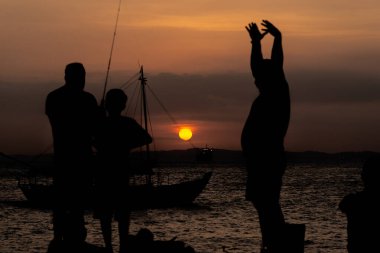 Salvador, Bahia, Brezilya - 16 Kasım 2019: Silhouette 'de birkaç kişinin gün batımında Salvador, Bahia' da dinlendikleri görüldü..