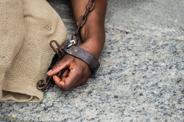 Elleri ve kolları zincirlenmiş, yerde yatıyordu. Brezilya 'da kölelik. Köle Anastacia 'nın temsilcisi.