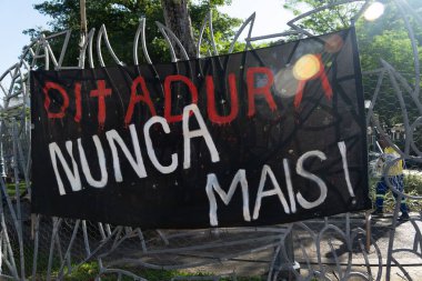 Salvador, Bahia, Brezilya - 10 Aralık 2024: Bahia 'nın Salvador kentindeki bir siyasi protesto sırasında diktatörlük sözcüğünün bir daha asla demir parmaklıklara bağlanmadığı büyük bir pankartın görüntüsü.
