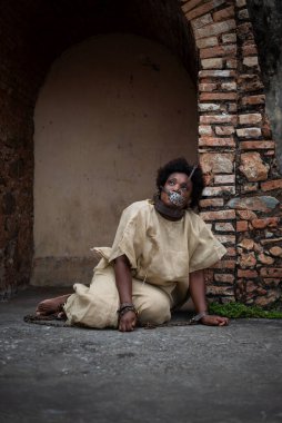 Ağzında demir bir maske ve zincirli siyah bir kadın Pelourinho 'nun zemininde oturuyor. Brezilya 'da kölelik. Köle Anastacia 'yı temsil ediyorum..