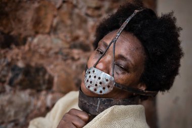 Ağzına demir bir maske takmış siyah bir kadının portresi. Zincirli. Brezilya 'da kölelik. Korku ve üzüntü hissi..