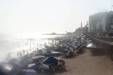 Salvador, Bahia, Brezilya - 05 Ocak 2025: Turistler öğleden sonra Farol da Barra plajında eğlenirken görülüyor. Salvador, Bahia.