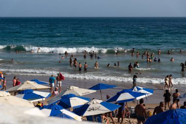 Salvador, Bahia, Brezilya - 05 Ocak 2025: İnsanlar güçlü güneş ışığı altında Farol da Barra plajında eğlenirken görülüyor. Salvador, Bahia. 