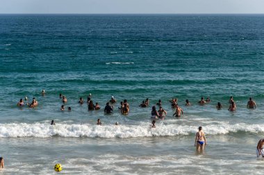 Salvador, Bahia, Brezilya - 05 Ocak 2025: İnsanlar Farol da Barra plajında güçlü öğleden sonra güneşi altında eğlenirken görülüyor. Salvador, Bahia. 
