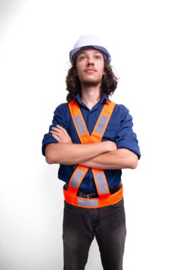 Beyaz kask ve parlak yelek giyen genç mühendis fotoğraf için poz veriyor. Güvenlik ekipmanları. Mimar