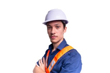 Beyaz kasklı ve parlak yelek giyen genç mimar kollarını kavuşturmuş fotoğraf için poz veriyor. Beyaz arka planda izole edilmiş. Güvenlik ekipmanları.