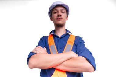 Beyaz kasklı ve parlak yelek giyen genç mimar kollarını kavuşturmuş fotoğraf için poz veriyor. Beyaz arka planda izole edilmiş. Güvenlik ekipmanları.