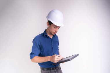 Tabletle çalışan beyaz kasklı genç bir mimarın portresi. Beyaz arka planda izole edilmiş. Güvenlik ekipmanları.