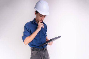 Tabletle çalışan beyaz kasklı genç bir mimarın portresi. Beyaz arka planda izole edilmiş. Güvenlik ekipmanları.