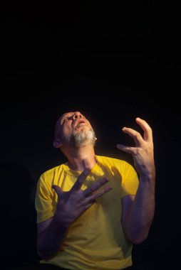 Olgun bir adam, 50 'li yaşlarda, kel ve sakallı, sarı gömlek giyiyor, endişe, korku ya da rahatsızlık gösteriyor. Psikolojik bakım konsepti. Brezilya