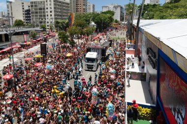 Salvador, Bahia, Brezilya - 01 Mart 2025: Çocuklar ve yetişkinler, Bahia 'nın Salvador kentindeki karnavalda bir elektrikli üçlünün geçişi sırasında eğleniyorlar.
