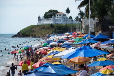 Salvador, Bahia, Brezilya - 31 Aralık 2024: İnsanlar ve turistler Salvador, Bahia 'daki Boa Viagem plajında güneşlenmenin ve yüzmenin keyfini çıkarıyorlar.