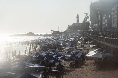 Salvador, Bahia, Brezilya - 05 Ocak 2025: Denizde yıkanan turistlerle dolu Farol da Barra plajının manzarası. Salvador, Bahia.