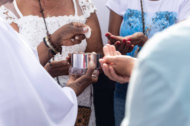 Salvador, Bahia, Brezilya - 27 Aralık 2024: Katolikler, 2024 yılının son Cuma günü ayin sırasında ağırlanırken görüldü. Bonfim Kilisesi, Salvador, Bahia.