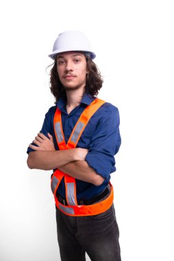 Beyaz kask ve parlak yelek giyen genç mühendis fotoğraf için poz veriyor. Güvenlik ekipmanları. Mimar