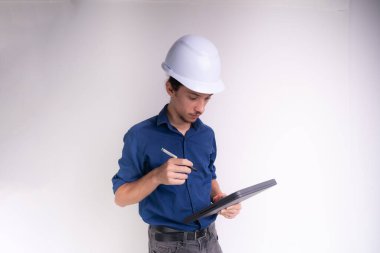 Tabletle çalışan beyaz kasklı genç bir mimarın portresi. Beyaz arka planda izole edilmiş. Güvenlik ekipmanları.