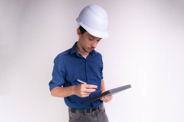 Tabletle çalışan beyaz kasklı genç bir mimarın portresi. Beyaz arka planda izole edilmiş. Güvenlik ekipmanları.