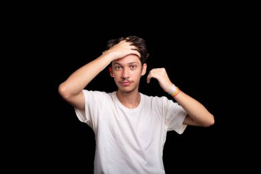Beyaz gömlekli yakışıklı bir gencin portresi. Saçına elinle dokunuyor ve fotoğraf için poz veriyor. Siyah arka planda izole edilmiş. Kafkasya Brezilyası.