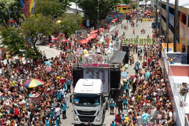 Salvador, Bahia, Brezilya - 01 Mart 2025: Salvador, Bahia 'daki karnaval sırasında pamuk helva elektrikli üçlüsünün tepesinden bir grup insanı sürükleyen görüntüler.