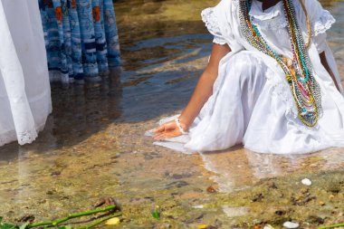 Rio Vermelho sahilindeki suda Iemanja 'ya hürmet eden bir Candomble uygulayıcısı görülüyor. Salvador, Brezilya.
