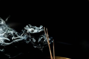 Karanlıkta tütsü dumanıyla dans etmek. Stüdyo çekimi.